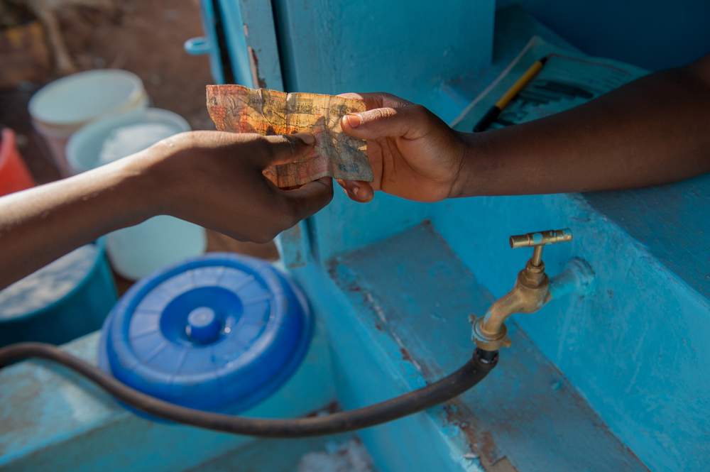 Paying for water at a water kiosk.©WSUP